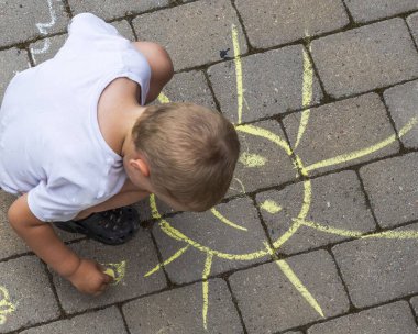 Tebeşirle asfalt döşeme üzerinde çocuk çizimine tepeden aşağı güzel bir manzara. İsveç. 