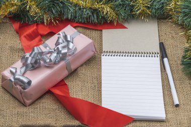 Kalem ve kitap masaüstü ile birlikte tatil kutularında paketlenmiş hediyelerin görüntüsünü kapat. Noel tatili kavramı. İsveç.