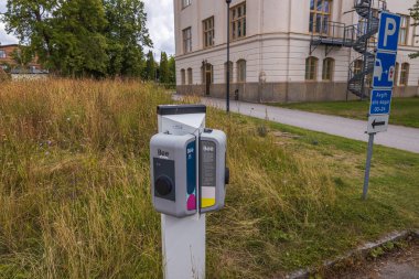 Otomobil parkındaki elektrik şarj istasyonunu kapatın. Uppsala, İsveç. Avrupa. 09.07.2021.