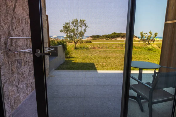 Beautiful view from hotel room at sea side through full size window with mosquito net. Greece.