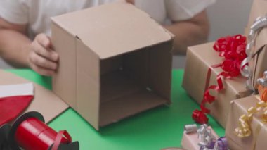 Noel hediyelerini paketleyen adamın yakın görüntüsü. Noel tatili kavramı. Kartpostal İsveç. 