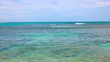 Calm turquoise waves of Atlantic Ocean shimmering in sunlight on warm day. Dominican Republic.