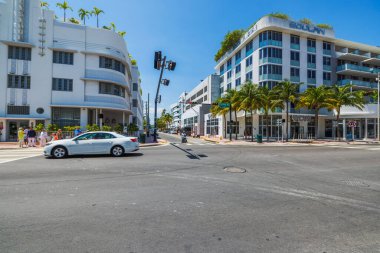 View of  intersection of Collins Avenue with palm trees, hotels, cars, and walking tourists on background. Miami Beach. USA. 