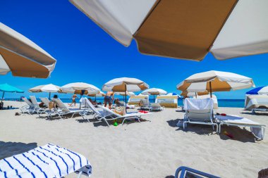 Atlantik Okyanusu kıyısındaki şezlonglarda güneşli bir günün tadını çıkaran turistlerle Miami Plajı 'nda rahat bir atmosfer. Miami Plajı. ABD. 