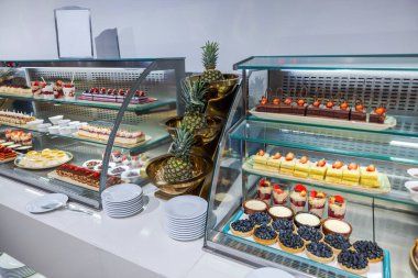 Otel restoranının vitrininde böğürtlenli ve ananaslı çeşitli pasta ve tatlılar. Curacao.