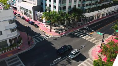 Collins Bulvarı 'nın üst manzarası ve arka planda palmiye ağaçları ve CVS mağazası olan 20 cadde kavşağı. Miami Plajı. ABD. 