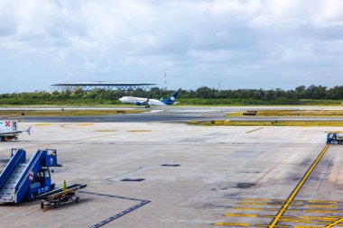 Hava alanından kalkan Aeromexico uçağı bulutlu gökyüzü ve yeşil orman hattının arka planında. Meksika mı? Cancun.. 