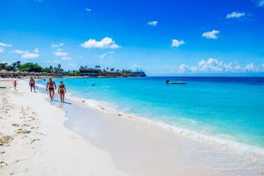 Turkuaz Karayip Denizi 'nin beyaz kumları ve Kartal Sahili boyunca yürüyen turistlerin güzel manzarası..