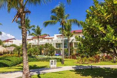 Güneşli bir günde palmiye ağaçları, parlak yeşillikler ve tatil köylerinin güzel manzarası. Punta Cana. Dominik Cumhuriyeti. 