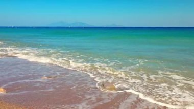 Ege Denizi 'nin kumlu sahildeki doğal stereo sesiyle dalgalanan yakın görüntüsü. Yunanistan. Kos.