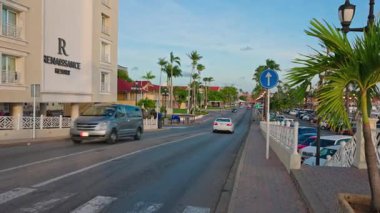 Oranjestad 'ın güzel manzarası şehir merkezi ana caddesi. Sürücü arabaları ve Rönesans Aruba Resort Oteli.. 