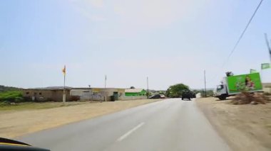 Güneşli bir günde renkli evleri ve rüzgarlı tropikal manzarası olan sakin Aruba mahallesinden bir cip turu..