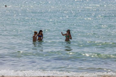 Güneşli bir günde dalgalar ve köpüklü suyla Atlantik Okyanusu 'nda yüzen insanların güzel manzarası. Miami Plajı. ABD.