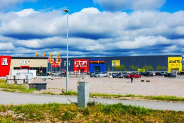 Süpermarket binaları, otopark arabaları ve alışveriş merkezinin yakınındaki marka tabelaları olan perakende alanı..