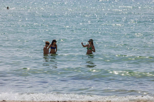 Güneşli bir günde dalgalar ve köpüklü suyla Atlantik Okyanusu 'nda yüzen insanların güzel manzarası. Miami Plajı. ABD.