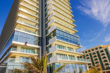 Endüstriyel tırmanışçıların pencereleri dış camlarda yıkadıkları modern otel binasının güzel manzarası. Meksika mı? Cancun..