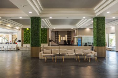 Modern otel lobisinin güzel manzarası kanepe masaları sütunları ve geniş tasarımlı. Kos. Yunanistan.