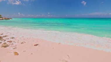 Turkuaz Karayip Denizi 'nin güzel manzarası kumlu sahiller, yumuşak dalgalar ve mavi gökyüzü arka planında sahil oteli. Aruba.