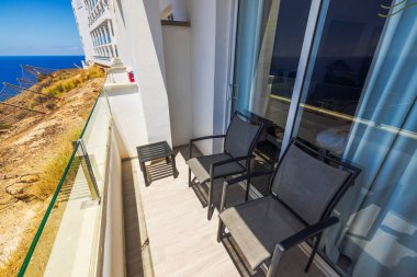 Büyük Kanarya 'daki Atlantik Okyanusu' na bakan sandalyeli otel balkonunun yakın görüntüsü. İspanya.