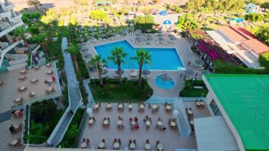 Ege Denizi yakınlarında yüzme havuzu ve palmiye ağaçları olan büyük bir otelin güzel manzarası. Rodos. Yunanistan.