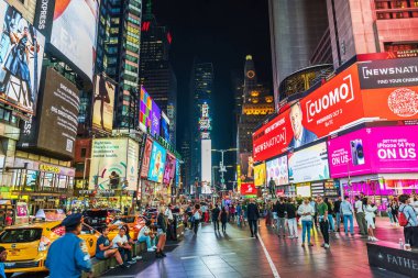 Times Meydanı 'nın ışıldayan dijital reklam panolarının altında turistlerle dolu güzel, canlı gece manzarası. - New York. ABD.