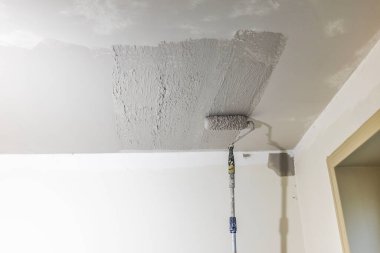 Oda tadilatı sırasında tavana sürülen kaygan paltonun yakın görüntüsü. İsveç.