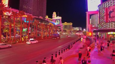 Planet Hollywood yakınlarındaki Las Vegas Bulvarı ve Caesars Sarayı 'nın güzel manzarası. Trafik ve geceleri yürüyen turistler. Las Vegas mı? ABD.