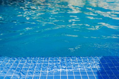 Sakin mavi yüzme havuzu suyu ve yumuşak ışık yansımaları yaz tatili atmosferini rahatlatıyor. Büyük Kanarya. İspanya.