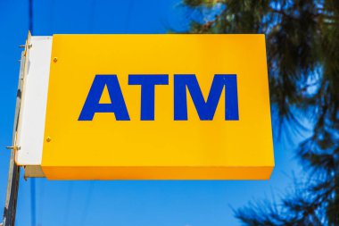 Mavi gökyüzünün arka planındaki ATM işaretinin yakın görüntüsü. Kardamena. Yunanistan.