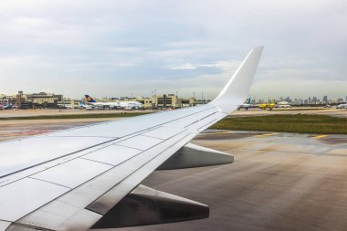 Miami Havaalanı 'nda yolcu uçakları ve terminallerle birlikte uçak kanadının görüntüsü. Miami mi? ABD.