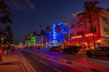 Neon Art Deco otelleri, palmiye ağaçları ve yoğun trafiği olan Ocean Drive 'ın güzel gece manzarası. Miami Plajı. ABD.