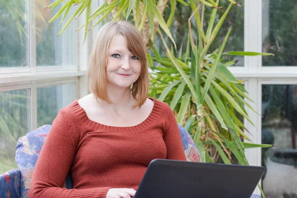 Jonge vrouw met laptop is kijken naar de camera — Stockfoto