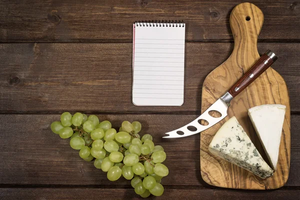 Cuaderno de queso, uvas y papel — Foto de Stock