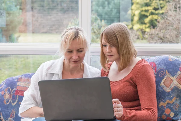 Vrouwen zijn op zoek naar een laptop samen intenly — Stockfoto