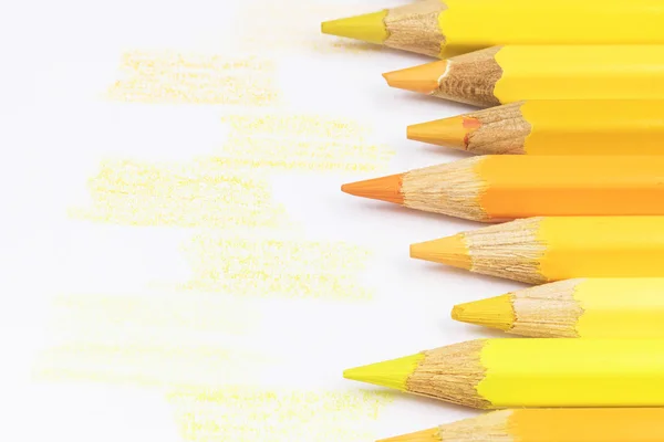 Желтые цветные карандаши и желтые образцы — стоковое фото