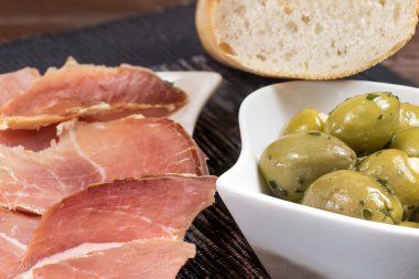 Dilimlenmiş Ispanyol jambon ve zeytin yakın ikramlar