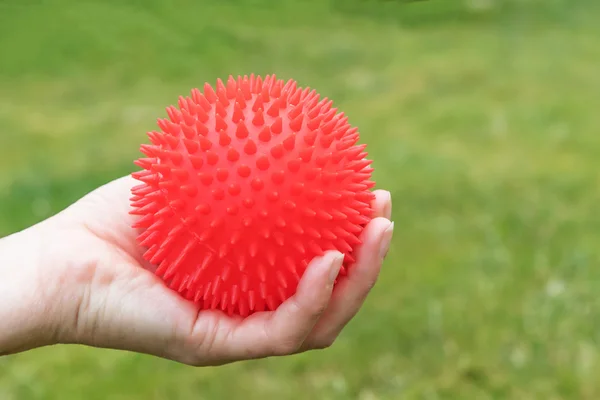 Manteniendo una pelota roja relajante de cerca —  Fotos de Stock