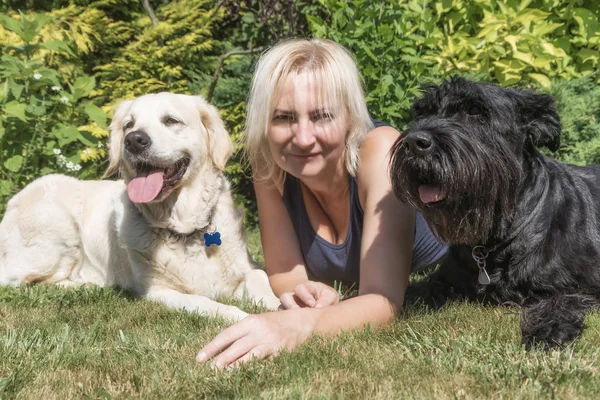 Junge schöne Frau bläst ihrem Hund im Park einen Kuss zu