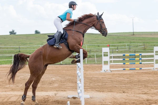Yüksek atlama sırasında binici kadın yan görünüm