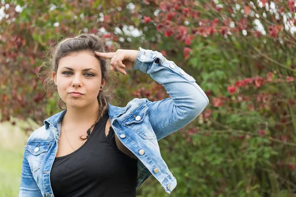 Teenage girl with finger pointing at her head — Stock Photo, Image