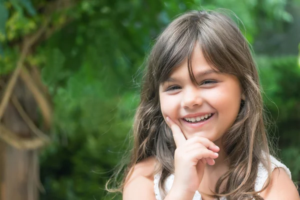 Portrét smějící se malá holčička s dlouhými vlasy — Stock fotografie