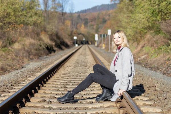 Junge Frau Sitzt Auf Den Gleisen Und Blickt Die Kamera — Stockfoto