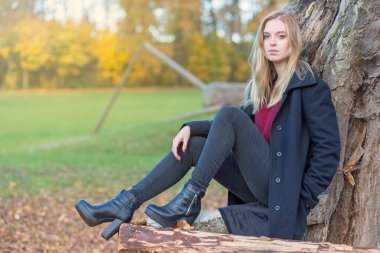 Sonbahar parkında genç bir kızın portresi. Kız kameraya bakıyor..