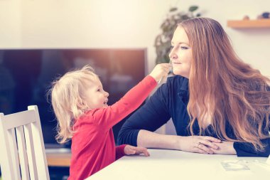 Gülen tatlı çocuk annesinin burnuna çubuk sokmuş. Antijen kullanım kitleri konsepti.