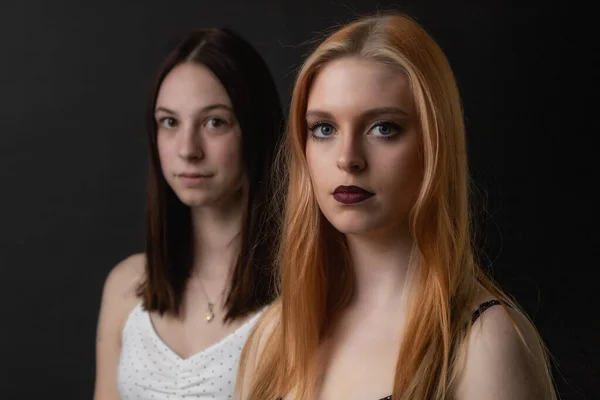 Auf Dem Schwarzen Hintergrund Posieren Zwei Junge Frauen Horizontal — Stockfoto