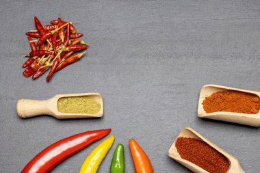 Masanın üstünde çok renkli taze kırmızı biber ve kuru kırmızı biber var. Yatay olarak.. 