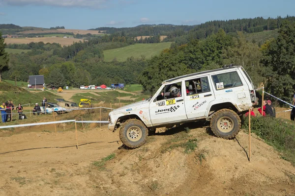 Carro off road branco está batendo em uma colina íngreme — Fotografia de Stock