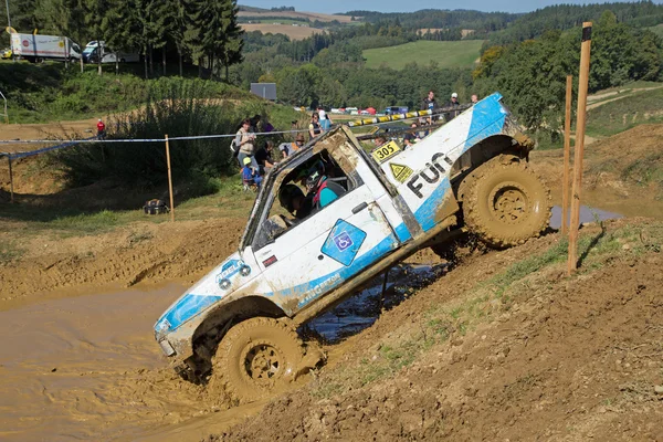 Blå och vit off road bil drar in i djup lera — Stockfoto