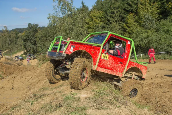 Petite voiture rouge hors route frappe une colline escarpée — Photo