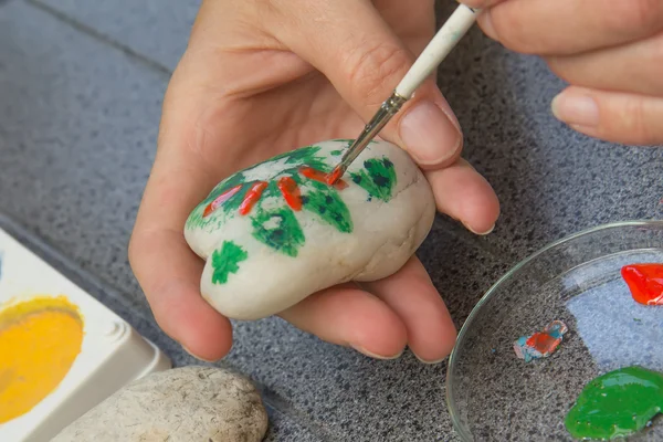 Женская рука рисует на камне — стоковое фото